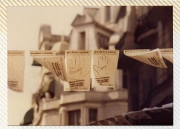 Campaña “Dele una mano a los desaparecidos, hileras colgantes de hojas-afiches de manos.
