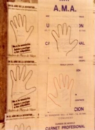 Campaña “Dele una mano a los desaparecidos", hojas-afiches de manos sobre muro urbano.