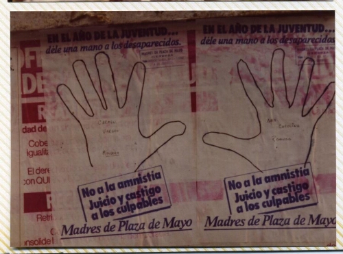 Campaña “Dele una mano a los desaparecidos", detalle de dos hojas-afiches de manos sobre muro urbano.