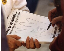 Campaña “Dele una mano a los desaparecidos", detalle de hojas-afiches de manos siendo intervenida.