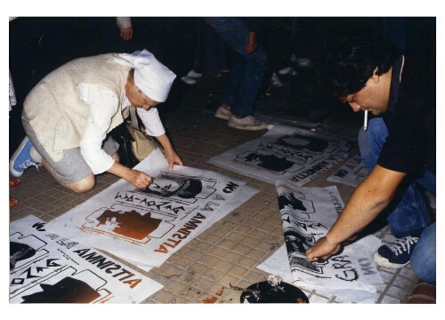 Una Madre de Plaza de Mayo pintando un afiche participativo