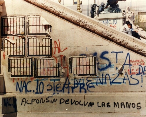 Serigrafías con los nombres de los militares represores y "carapintadas" revelados contra la democracia, en el monumento de Plaza Congreso. Pintada: Alfonsín devolvé las manos.