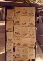 Campaña “Dele una mano a los desaparecidos", hojas-afiches de manos  pegadas sobre un kiosko.